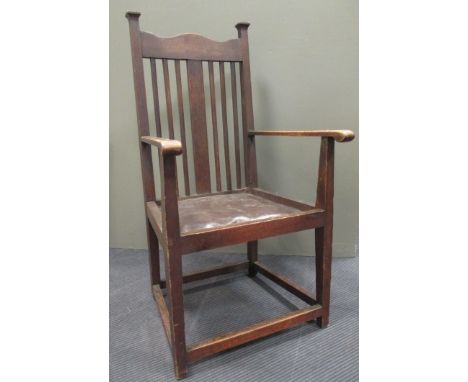 An Arts & Crafts oak stick back armchair,with drop-in seat