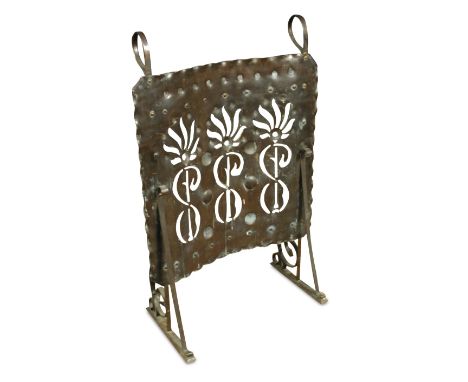 An Arts & Crafts copper fire screen, the curved panel with pierced and embossed decoaration to a scrolling wrought iron frame