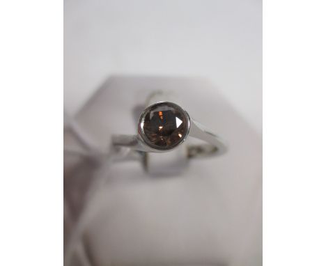 A fancy orange-brown diamond and platinum ring, the round brilliant cut diamond, estimated approx. 0.44cts, collet set to an 