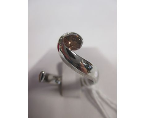 A fancy brown diamond and platinum ring, the round brilliant cut diamond, estimated approx. 0.57cts, tension set in a curl of