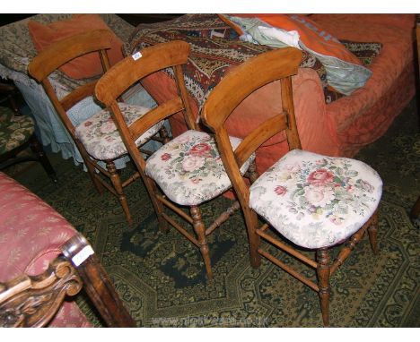 A set of three stripped Beech Dining Chairs having shaped top rail with single bar back, applied cream ground floral print fa