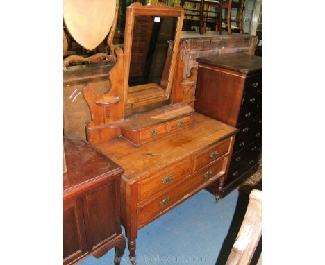 A late Victorian Walnut Dressing Chest with rectangular bevel plate mirror in carved top frame, fret-cut scroll supports, dem