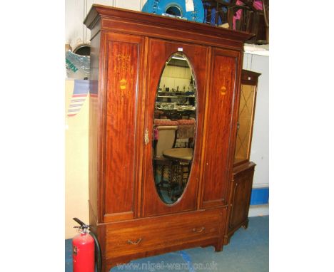 An Edwardian Mahogany single door Wardrobe having moulded cornice over central single door with full length oval bevel plated