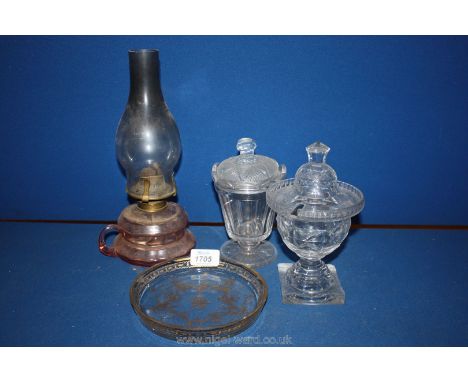 A small pink glass oil lamp, two lidded jam pots and lids etc.
