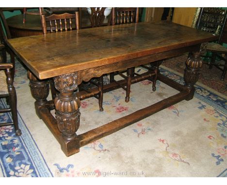 A substantial Oak 17th c. style Refectory Dining Table having thick four plank top, plain frieze, on heavy carved baluster tu