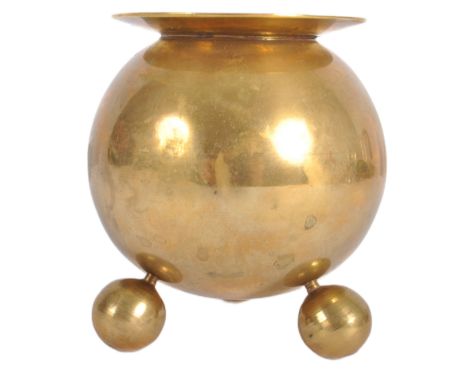 A retro mid 20th Century designer brass candlestick holder having a lipped rim over a spherical body supported by three brass