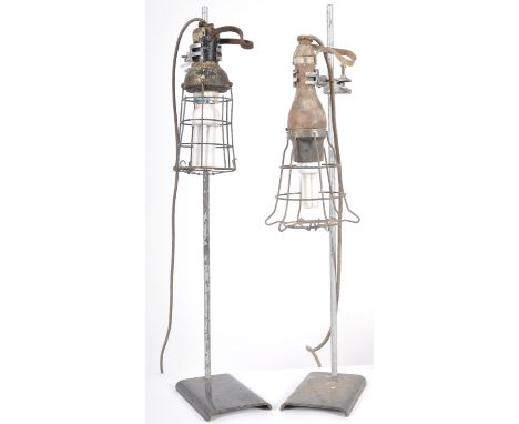 A pair of retro vintage mid 20th Century industrial inspection lamp lights with each having wooden handles with wire cages su