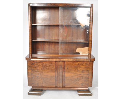 A large vintage 20th Century Art Deco walnut veneer bookcase cabinet having a twin glass sliding door display top with two ad