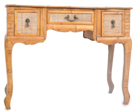 A vintage early 20th Century breakfront bamboo desk / dressing table having a central drawer over the knee hole recess flanke