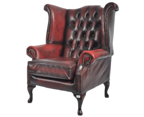 A Queen Anne revival oxblood red leather oxblood Chesterfield wingback armchair raised on cabriole legs with pad feet. The ch