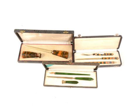 Three Art Deco Bakelite and gilt metal writing sets, a presentation boxed set of letter opener and wax seal in a marbled ambe