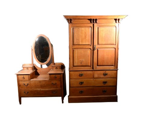 An Edwardian oak dressing table, oval bevelled plate, the supports with trinket drawers, two short drawers, above two long dr