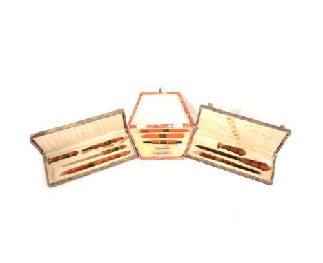 Three Art Deco amber coloured Bakelite writing sets, a three piece set comprising wax seal, letter opener, dip pen in a green