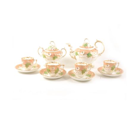 A Rockingham style tea service, 19th century, green leaves and pink flowers against a peach border, gilt outlines, including 