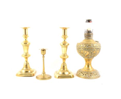 A pair of brass candlesticks, square base, 25cm, a smaller brass candlestick, 14.5cm, a brass oil lamp base converted to elec