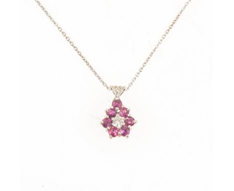A ruby and diamond pendant and chain, a brilliant cut diamond surrounded by seven round rubies, claw set in an all white meta