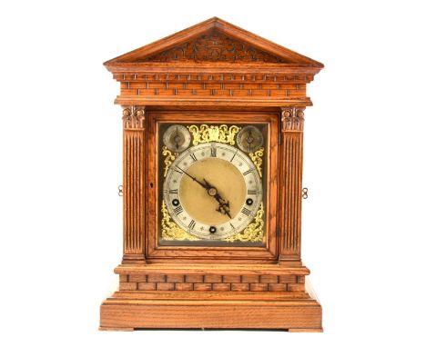 A late Victorian oak mantel clock, architectural case, moulded pediment, blind fretwork carving, Corinthian columns to the do