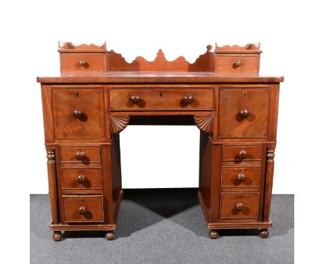 A Victorian mahogany kneehole desk/ dressing table, with two trinket drawers to the rectangular top, crossbanded outline, abo