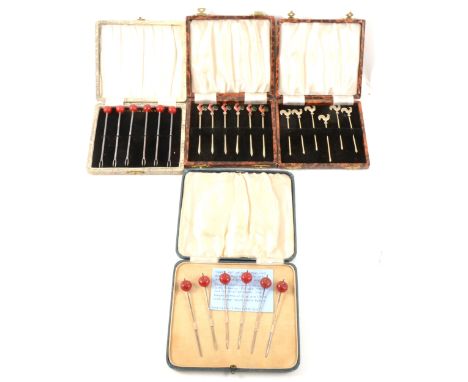 A set of six white metal "cherry" cocktail sticks, stamped sterling silver, a similar silver-plated set, a set of six silver-