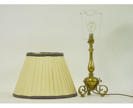 A brass table lamp, on scrolled supports, 54cm high overall