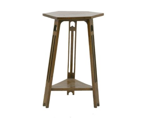 An Arts and Crafts oak hexagonal lamp table, with pierced supports over a trangular undertier, 42cm diameter, 72.5cm high