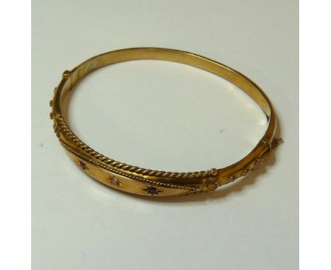 A gold diamond and ruby bangle