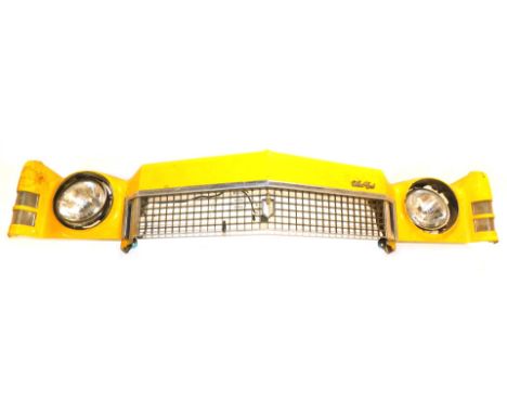 A Chevrolet Monte-Carlo yellow taxi car front bumper fascia, with two head lamps and front grille, in yellow, 175cm long.