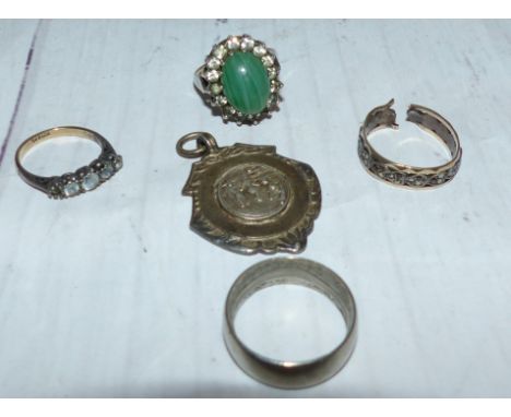 A ring set with a jade coloured stone; 3 other rings and a medallion