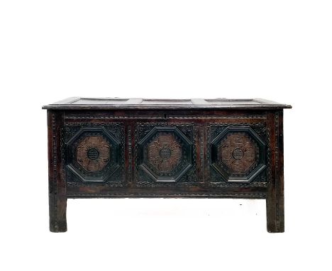 A 17th century oak coffer. With three carved front panels, lift up the rectangular lid on block feet, height 71cm width 132cm