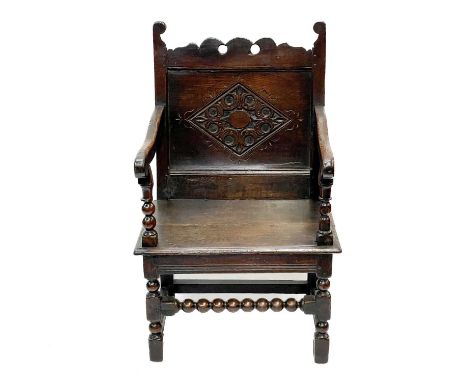 A 17th century North Country bobbin Wainscot chair. With a shaped top rail, central carved lozenge and bobbin stretcher, heig