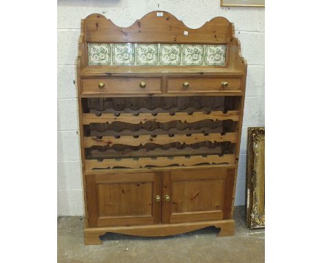 A pine low dresser, the tiled back and shelf above two drawers, three bottle racks and a pair of doors, 100cm wide, 149cm hig