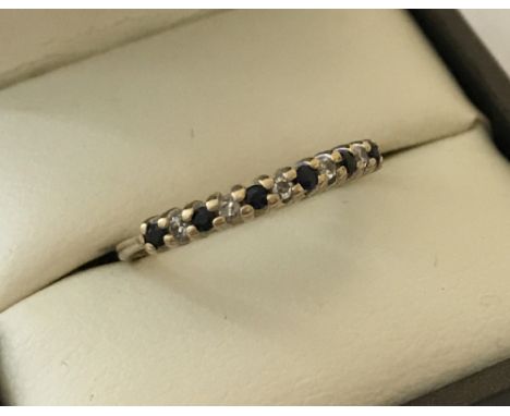 A 9ct gold sapphire and diamond half eternity ring. Set with 7 small sapphires and 5 small diamonds. Being sold on behalf of 