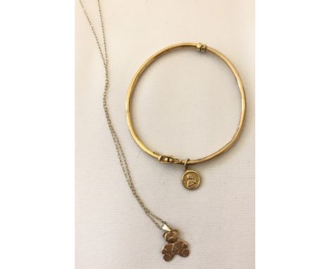 A 9ct gold thin bangle with small circular cherub charm. Together with a child's teddy bear pendant on a fine curb chain test