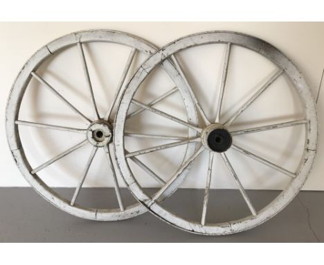 A pair of white painted vintage cart wheels.  Approx diameter 90cm.