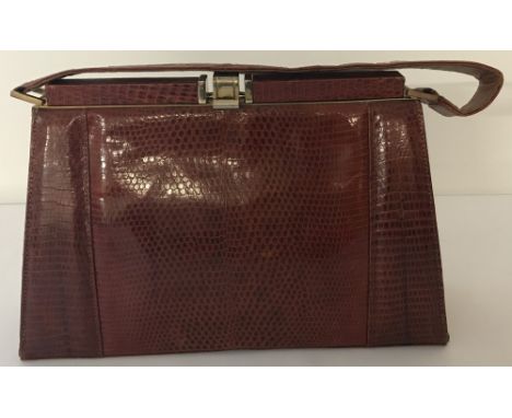 A vintage 1950's lizard skin Kelly handbag with soft leather interior. Gold coloured fastening, interior pockets and lizard s