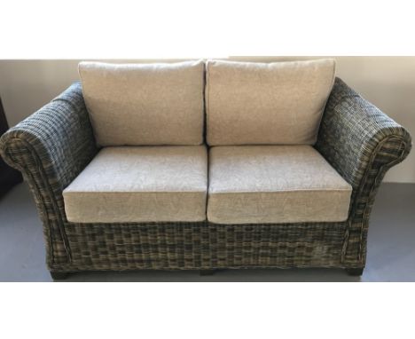 A 2 seater cane sofa with beige coloured cushions.  Approx 150cm wide.