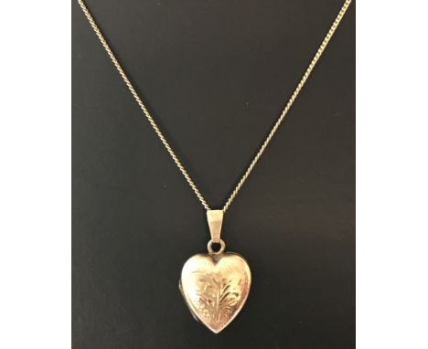 A 9ct gold front and back heart shaped locket on a 18 inch 9ct gold fine curb chain. Floral engraving to front of locket. Bei
