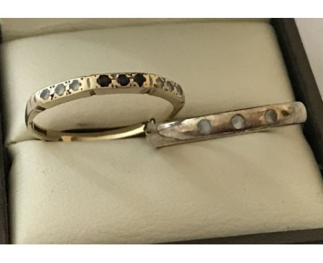 2 ladies 9ct gold dress rings. One set with 3 small clear stones and the other set with clear and dark blue cubic zirconia's.