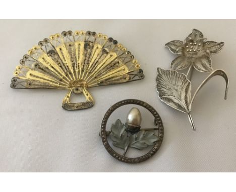 3 vintage silver brooches. A filigree lily, a filigree open fan with gold overlay decoration and a circular brooch with acorn