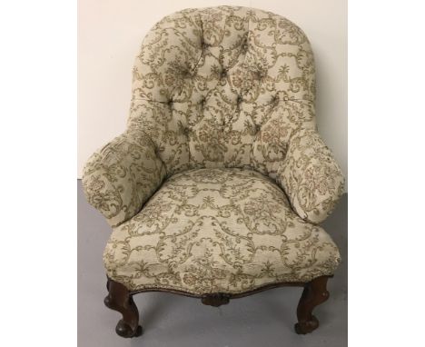 A vintage cream upholstered button backed nursing chair. With shaped front legs and ceramic casters. 