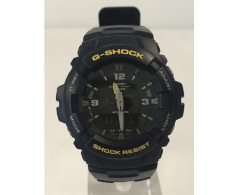 A men's Casio G-Shock wristwatch with dark blue strap. Hours and minutes hands together with digital display. Shock resistant