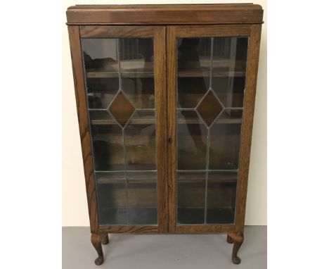 A vintage dark wood 2 door glass cabinet with leaded glass doors. On small cabriole Legs and with 3 Interior movable shelves.