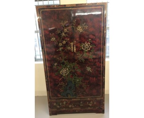 A Chinese red and black lacquer 2 door, single drawer wardrobe. With Oriental blossom and bird decoration to front and sides.