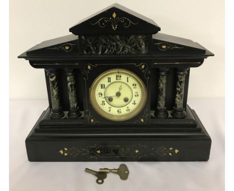 A antique slate and marble mantle clock with inlay detail. Enamel dial, 4 column decoration to front. Glass panel door to bac