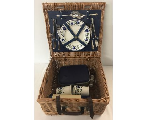 A vintage Optima wicker picnic basket with leather straps. Containing settings for two plus modern flask and cruet. Approx 38