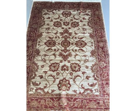 A Ziegler pattern rug; beige background with red and gold colouration. Tasselled ends. Approx. 190cm x 140cm.