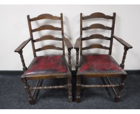 A pair of oak ladder back carver armchairs 
