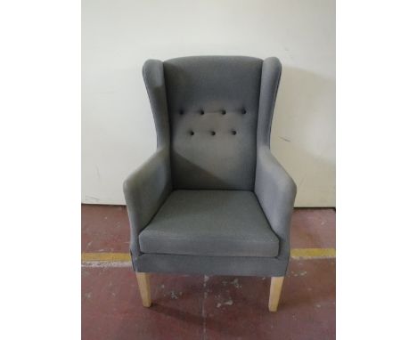 A twentieth century wing back armchair upholstered in a blue button fabric
