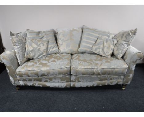 A contemporary scroll arm settee, upholstered in a gold and silver floral print