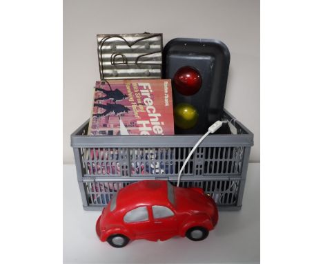 A box containing an electric traffic light, VW Beetle lamp, boxed fire helmet, bar signs etc